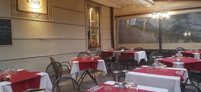 מרפסת מקורה עם מפות אדומות ולבנות, לוח גיר על הקיר ופנס תאורה