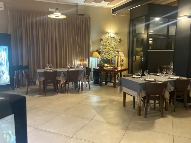 אולם אוכל מרוצף עם שולחנות ערוכים במפות אפורות ומנורה תלויה מעל